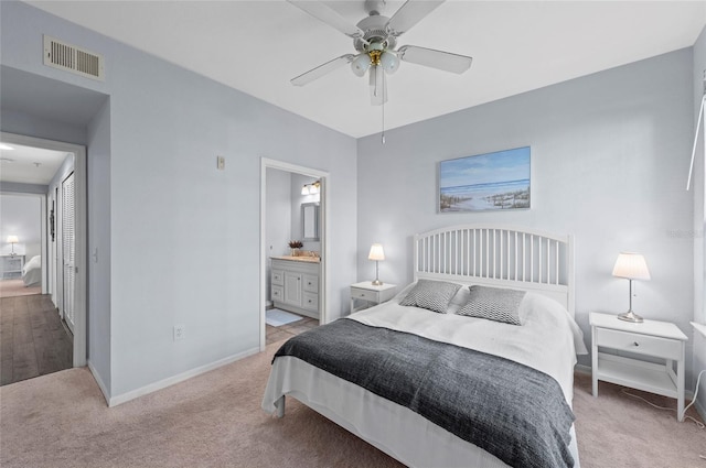 bedroom with connected bathroom, ceiling fan, and light colored carpet