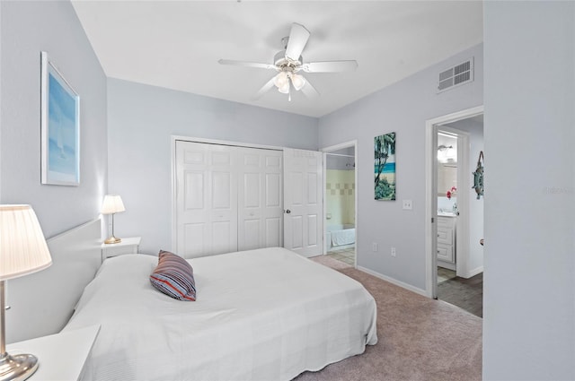 carpeted bedroom featuring ceiling fan, a closet, and ensuite bath