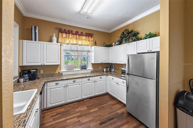 kitchen with appliances with stainless steel finishes, dark hardwood / wood-style floors, and white cabinetry