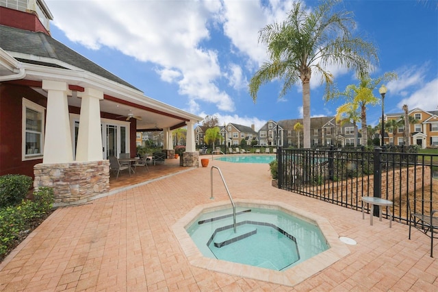 view of pool featuring ceiling fan, a community hot tub, and a patio