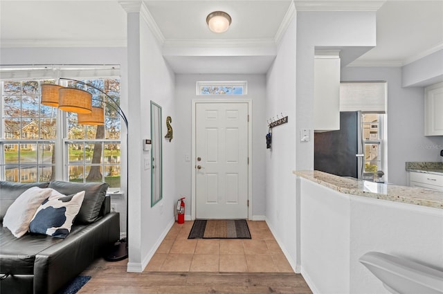 tiled entrance foyer featuring crown molding