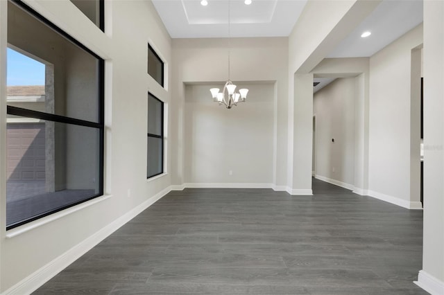 unfurnished room with dark wood-type flooring and a notable chandelier