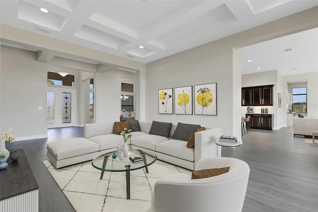 living room with beamed ceiling, coffered ceiling, and light hardwood / wood-style flooring