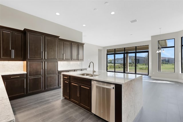 kitchen featuring tasteful backsplash, stainless steel dishwasher, dark brown cabinetry, sink, and pendant lighting