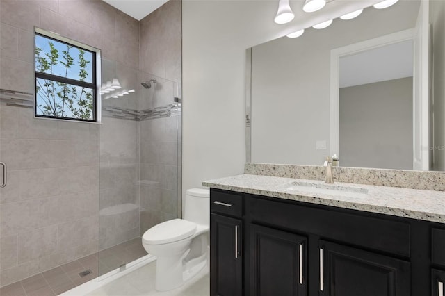 bathroom featuring tile patterned flooring, vanity, toilet, and a shower with door