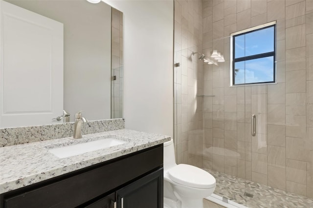 bathroom with walk in shower, vanity, and toilet