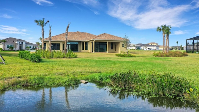 rear view of house featuring a yard and a water view