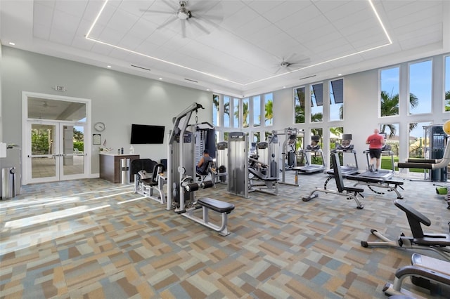 exercise room featuring a high ceiling, ceiling fan, and a healthy amount of sunlight