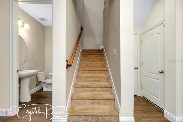 staircase featuring lofted ceiling and wood-type flooring