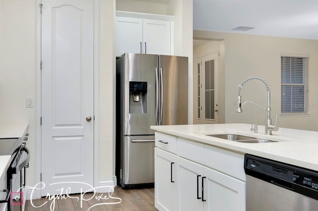 kitchen with white cabinetry, light hardwood / wood-style flooring, stainless steel appliances, and sink