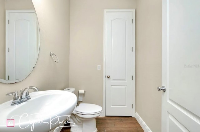 bathroom featuring hardwood / wood-style floors, toilet, and sink