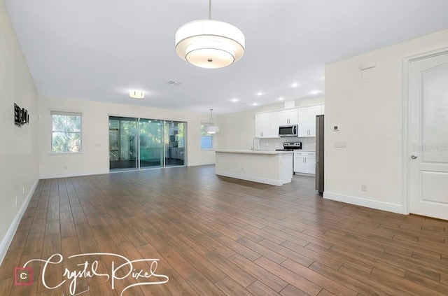 unfurnished living room with dark hardwood / wood-style floors and sink