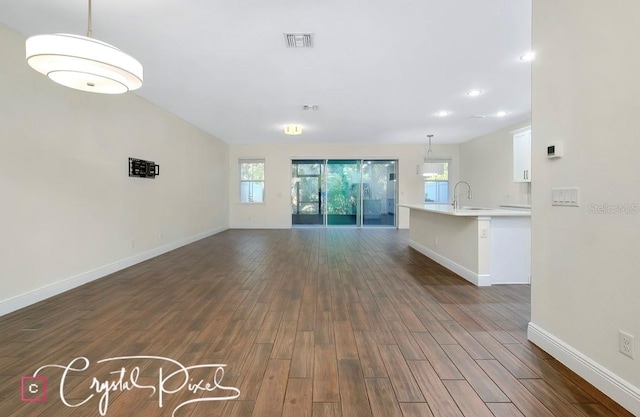 unfurnished living room featuring dark hardwood / wood-style flooring and sink