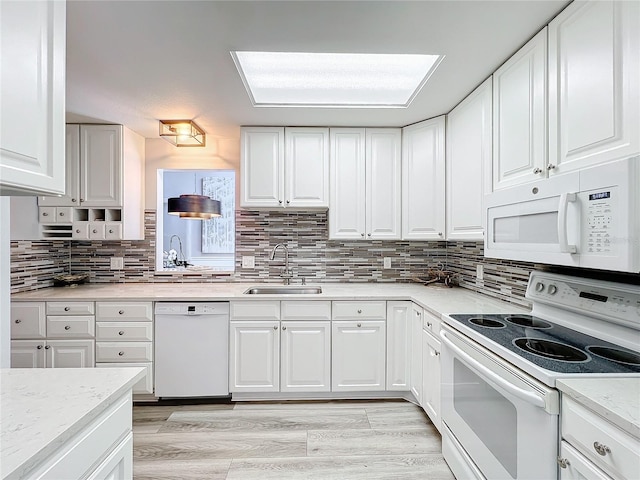 kitchen featuring white cabinetry, sink, tasteful backsplash, light hardwood / wood-style flooring, and white appliances