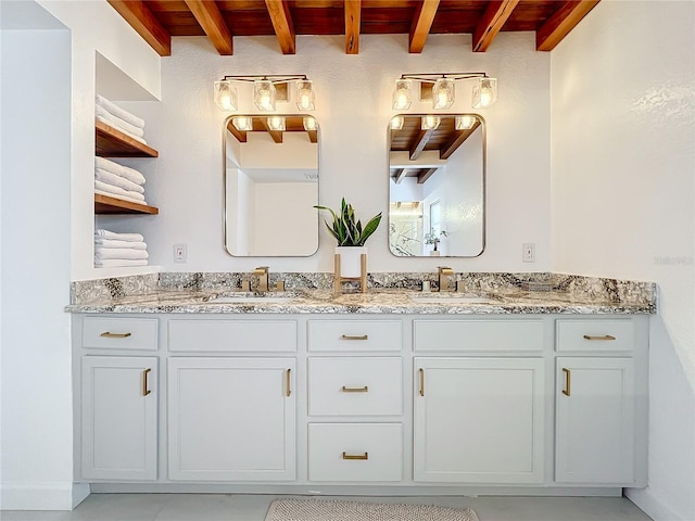 bathroom with beamed ceiling and vanity