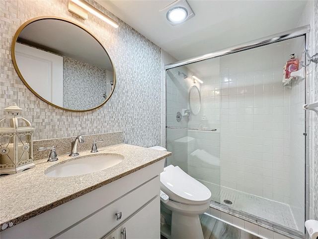 bathroom with tasteful backsplash, vanity, tile walls, toilet, and a shower with shower door