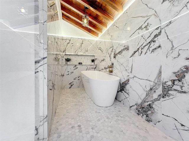 bathroom with wood ceiling, a washtub, lofted ceiling with beams, and tile walls