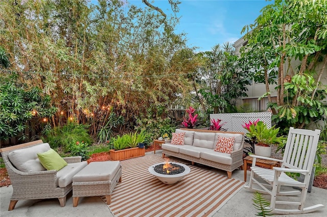 view of patio with an outdoor living space with a fire pit