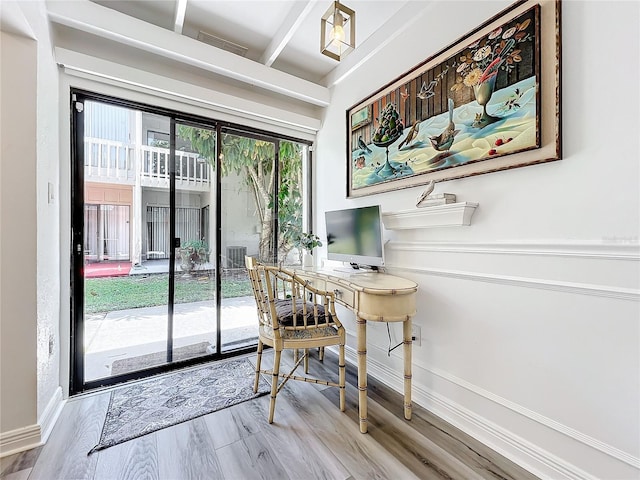 home office with beamed ceiling and hardwood / wood-style flooring