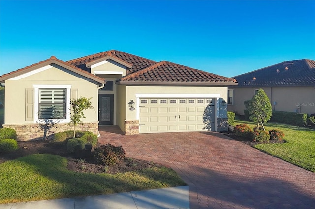 mediterranean / spanish-style home with a garage and a front lawn