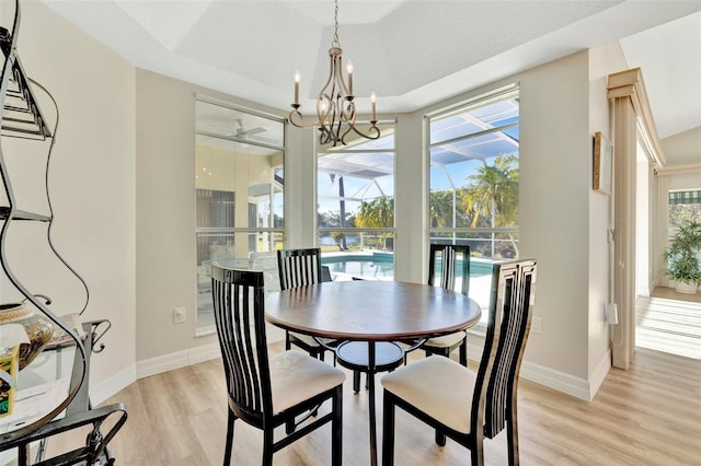 dining space featuring light hardwood / wood-style flooring and ceiling fan with notable chandelier