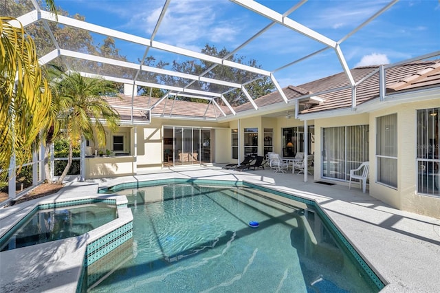 view of swimming pool with a patio area, a lanai, and an in ground hot tub