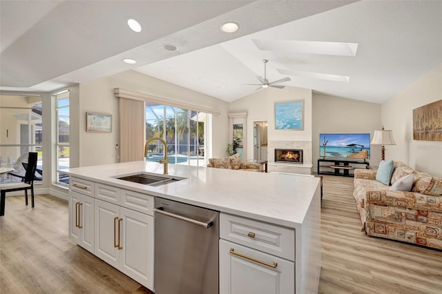 kitchen featuring white cabinets, light wood-type flooring, sink, and a kitchen island with sink