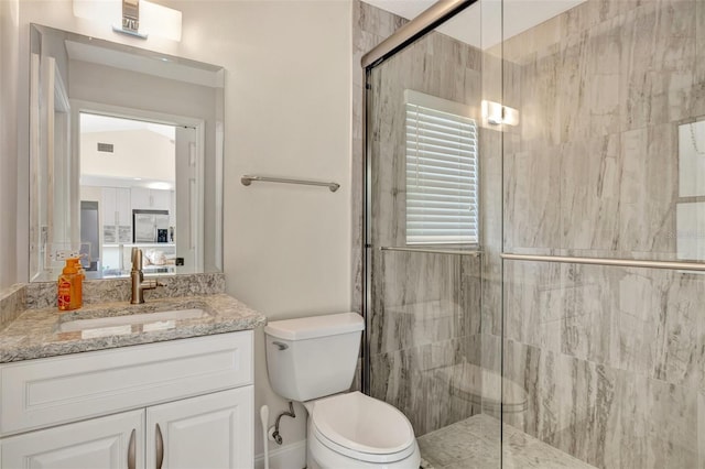 bathroom featuring vanity, toilet, and an enclosed shower