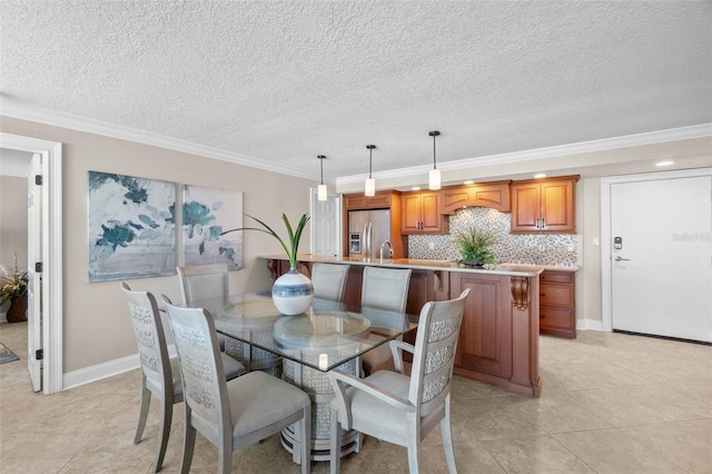 dining space featuring crown molding, sink, light tile patterned floors, and a textured ceiling