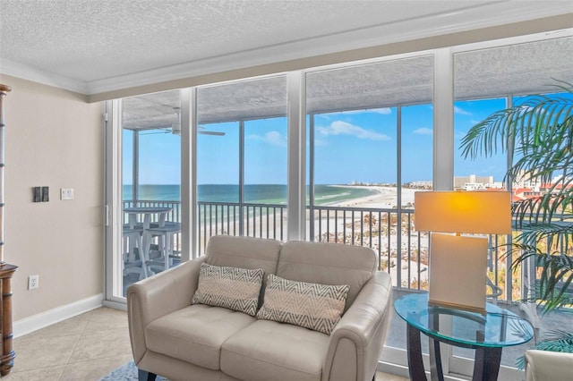 sunroom featuring a water view and a view of the beach