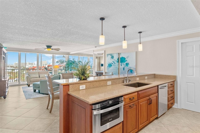 kitchen featuring pendant lighting, sink, crown molding, a textured ceiling, and stainless steel appliances