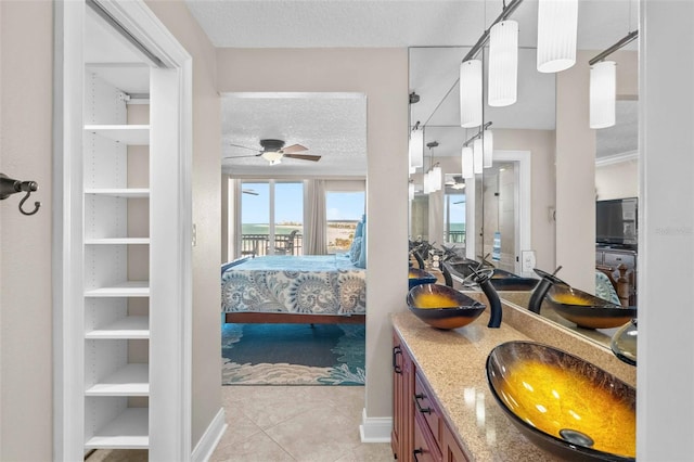 bathroom with vanity, tile patterned flooring, ceiling fan, built in features, and a textured ceiling