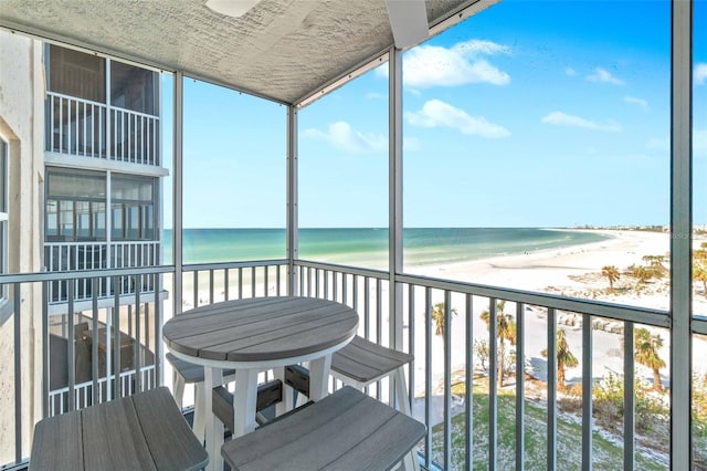 balcony featuring a beach view and a water view