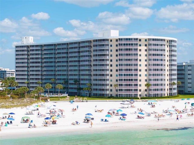 view of building exterior with a water view and a beach view