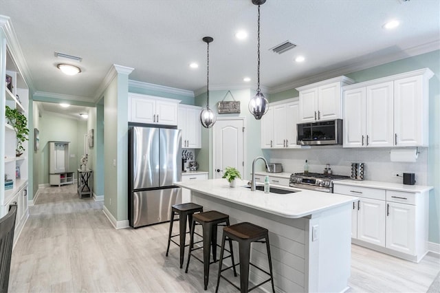 kitchen with sink, white cabinetry, a center island with sink, and stainless steel appliances