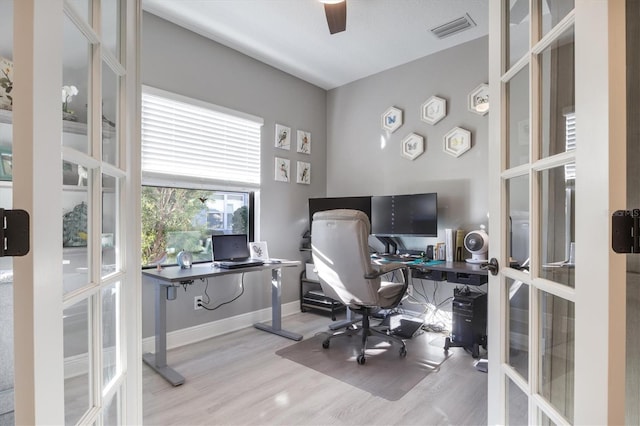 office space with french doors, ceiling fan, and light wood-type flooring