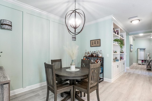 dining area featuring a chandelier, built in shelves, light wood-style flooring, visible vents, and ornamental molding