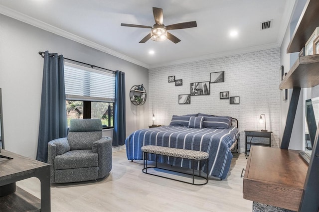 bedroom with brick wall, a ceiling fan, visible vents, light wood-type flooring, and crown molding