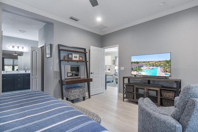 bedroom with visible vents, ensuite bathroom, light wood-style floors, ornamental molding, and baseboards