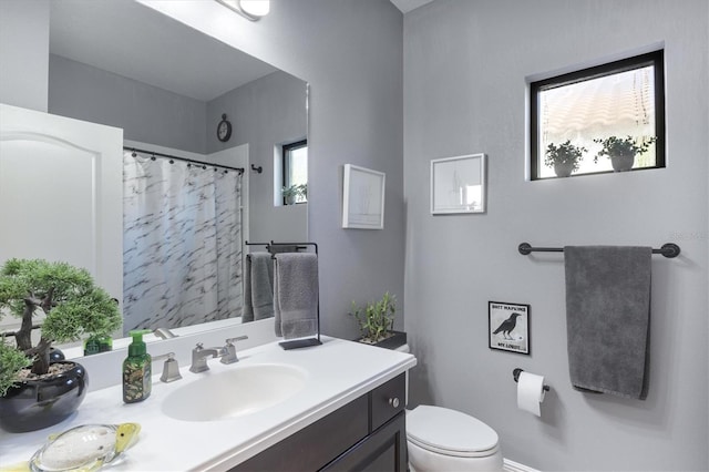 bathroom featuring a shower with curtain, vanity, and toilet