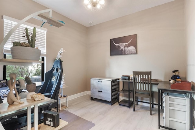 office area with light wood-type flooring, baseboards, and a chandelier