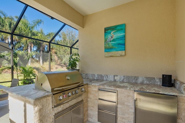 view of patio with a lanai, an outdoor kitchen, and grilling area