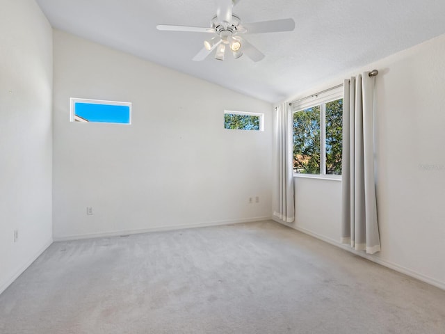 empty room featuring ceiling fan, light colored carpet, and lofted ceiling