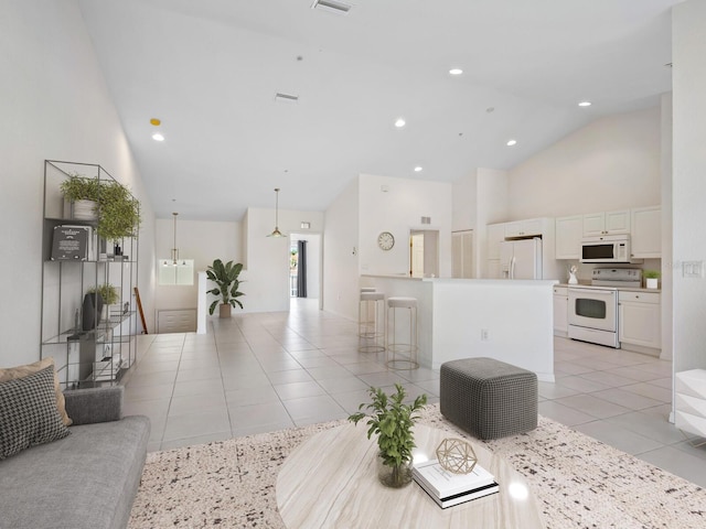 living room with light tile patterned floors and high vaulted ceiling