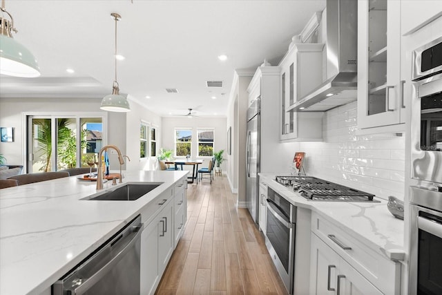 kitchen featuring appliances with stainless steel finishes, white cabinetry, a wealth of natural light, and sink