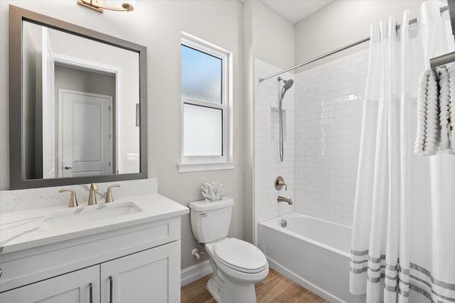 full bathroom featuring hardwood / wood-style floors, vanity, shower / tub combo, and toilet