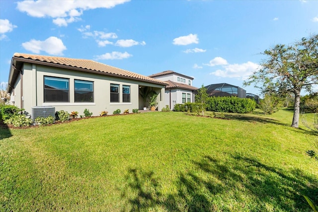 back of property with a lawn and central air condition unit