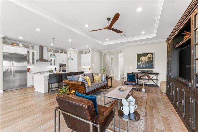 living room featuring recessed lighting, a ceiling fan, visible vents, a tray ceiling, and light wood finished floors