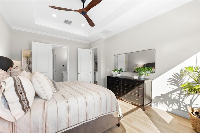 bedroom with recessed lighting, visible vents, ornamental molding, a tray ceiling, and light wood finished floors