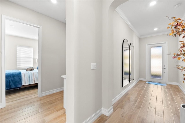 corridor featuring recessed lighting, baseboards, crown molding, and light wood finished floors